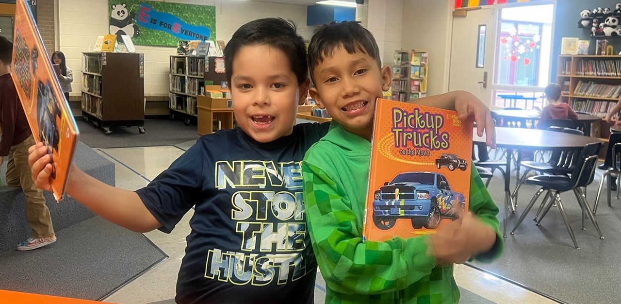 2 boys holding up library books